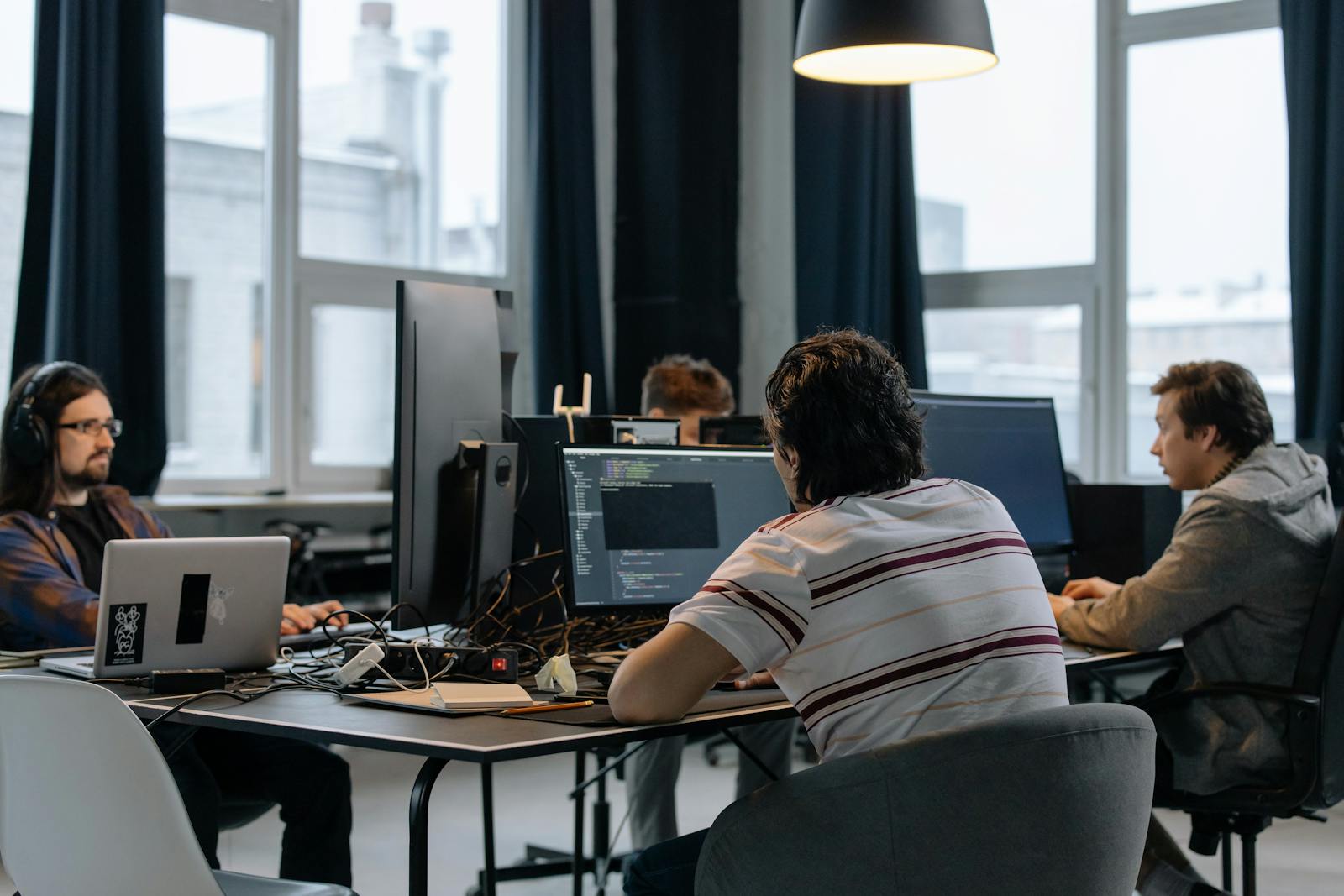 Echipa Webtopocket de dezvoltare software lucrand la cod intr-un birou modern